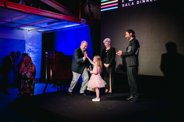 Comic moment with a child two men and a woman on the stage of Act for Peace