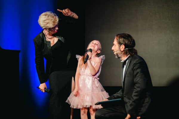 Comic moment with a child two men on the stage of Act for Peace