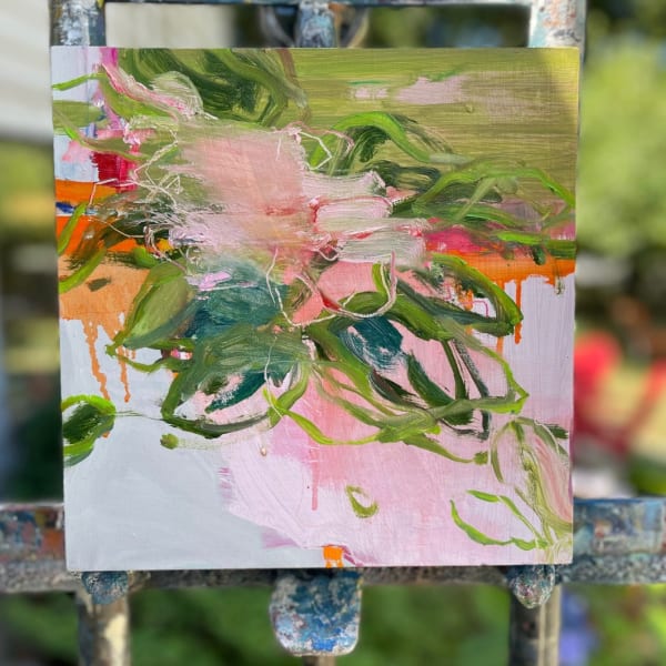 close up of a pink abstracted flower painting on easel in a garden
