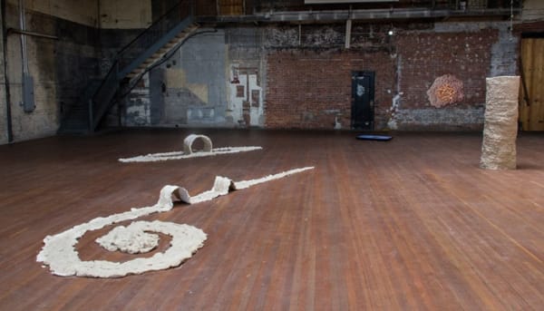 Brie Ruais, How to Wander (Push double your body weight in clay in a spiral, create hiccups along the way, then arbitrarily strike out in one direction.) 260lbs, 2016, installation view, Young World, unfired clay. Courtesy of the artist.