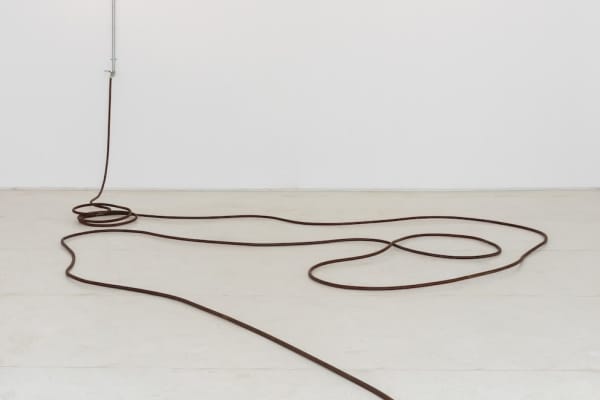 Tatiana Blass. O fim continua, 2022. Instalação Com Mangueira De Ferro, Torneira, Encanamento, Corte No Chão. Dimensões variáveis. Foto: Ana Pigosso.