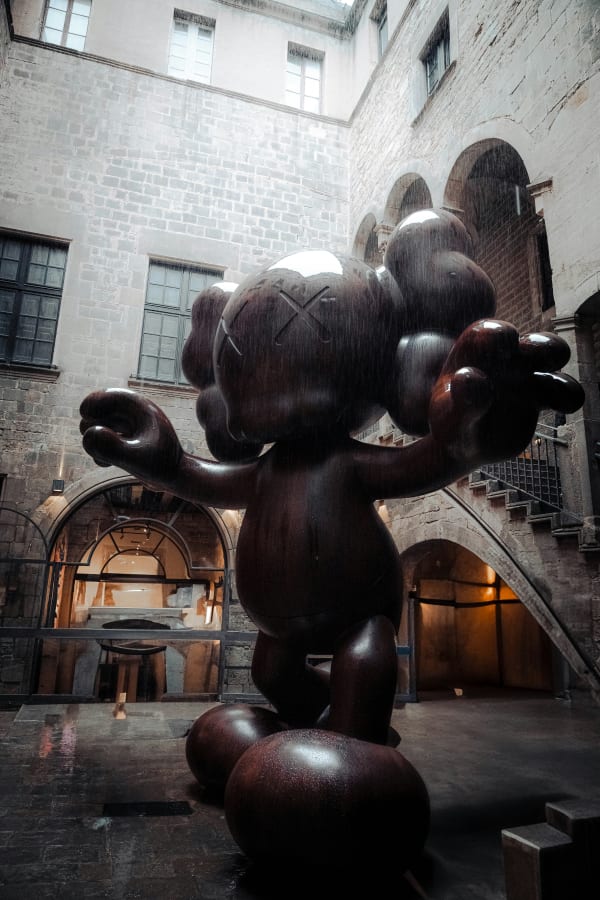 KAWS Companion large-scale sculpture installation in courtyard setting showcasing the monumental presence of the artist's iconic character in public space