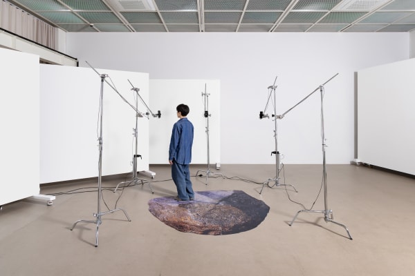 Daisy-Chain-Agora, 2023, iPhone, steel stand, grip head with arm, charger, cable, adhesive PVC sheet, dimensions variable, 5-channel video, 27min(loop), color, sound, AI model(GPT-4, Stable Diffusion), Curtesy of Unreal Studio