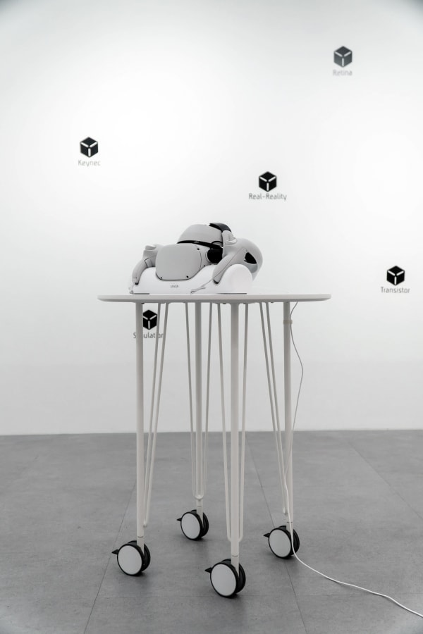 Sword of Damocles, 2022, head-mounted display, charger dock table, interactable VR simulation, 15min, HMD 19 x 10 x 14 cm, chargerdock 38 x 8.5 x 7 cm, table 60 x 60 x 62 cm, Curtesy of the Artist.