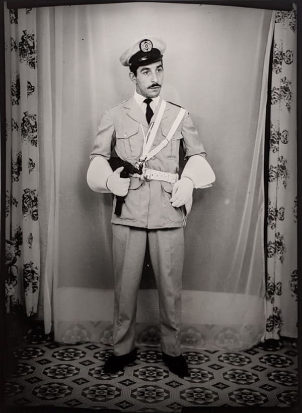 Black and white photograph of a man in a portrait studio