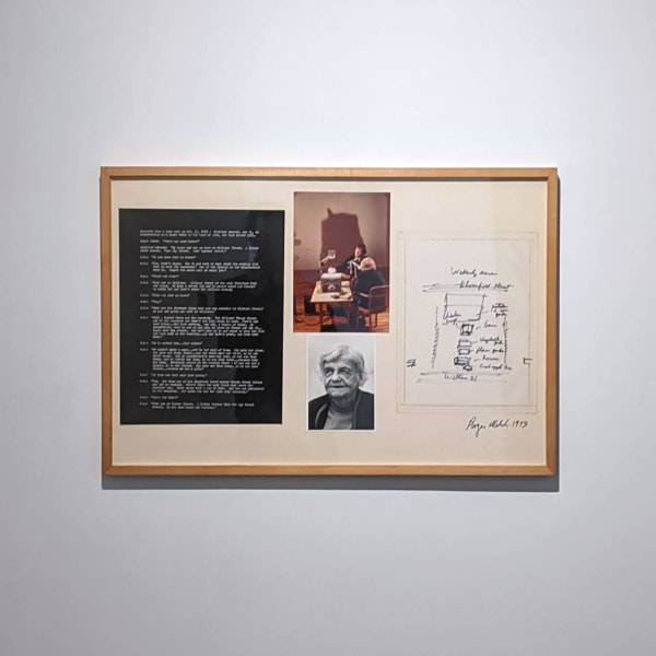 A photograph of an artwork consisting of photographs and writing framed and hanging on a white wall