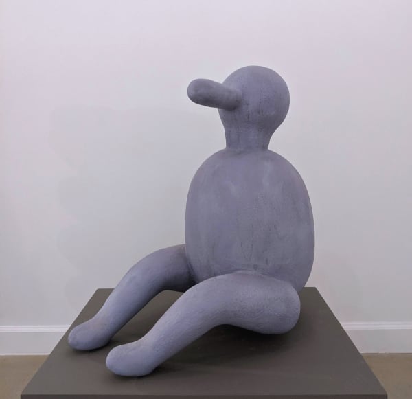 Abstracted anthropomorphic sculpture of a blue seated person