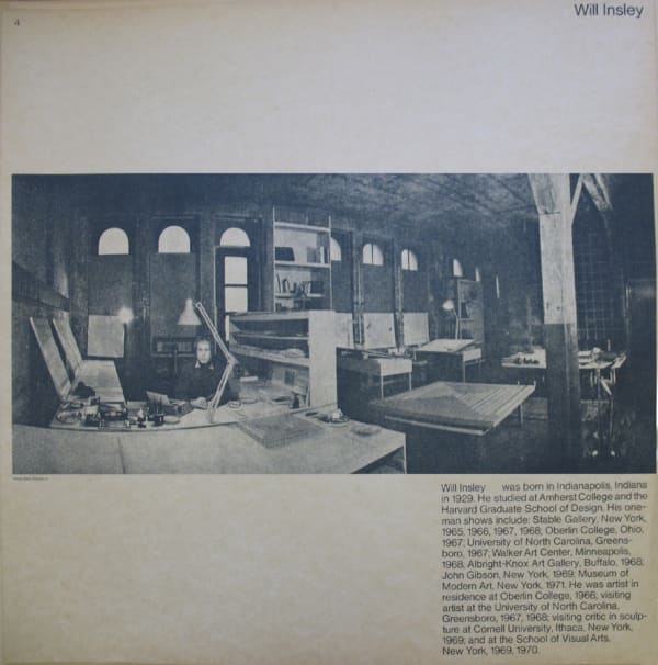 Black and white photograph of Will Insley in his studio with text underneath
