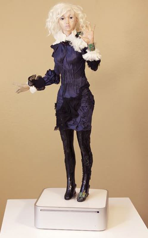 Photograph of a female doll on a white platform