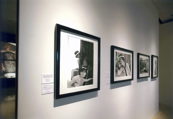 Four black and white photographs of Coco Chanel taken by Douglas Kirkland in 1962 are displayed on a white wall of the Chanel Boutique Exhibition Space in Honolulu, Hawaii