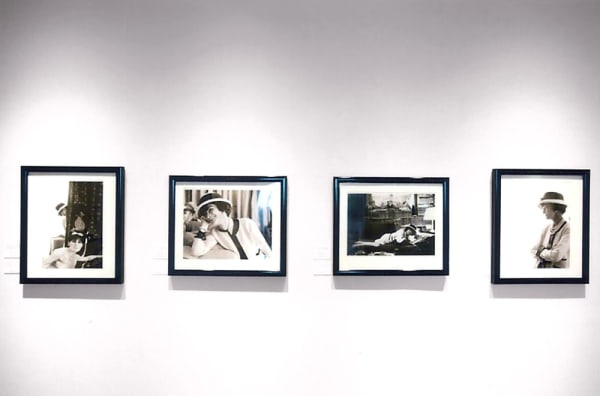 Four black and white photographs of Coco Chanel taken by Douglas Kirkland in 1962 are displayed on a white wall of the Chanel Boutique Exhibition Space in Honolulu, Hawaii
