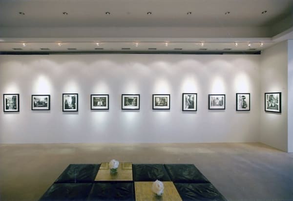 Many black and white photographs of Coco Chanel taken by Douglas Kirkland in 1962 are displayed on a white wall of the Chanel Boutique Exhibition Space in Honolulu, Hawaii