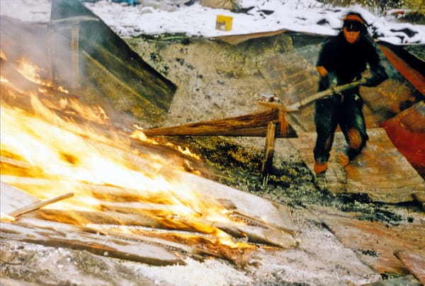 Artist Nobuho Nagasawa shoveling wood onto an earthwork in Berlin