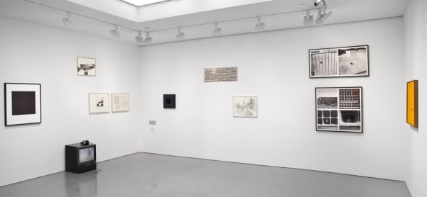 Gallery installation view of abstract paintings, found object wall sculptures, TV screen
