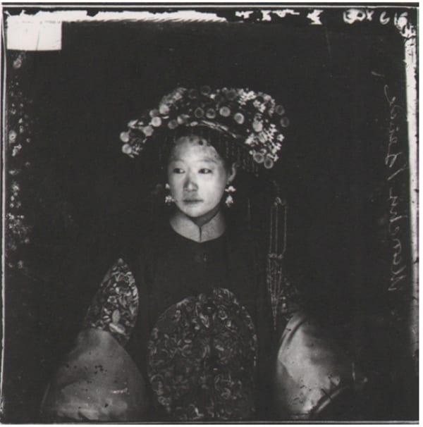 Period photograph of a young Chinese bride, wearing an elaborate head-dress and an embroidered outfit