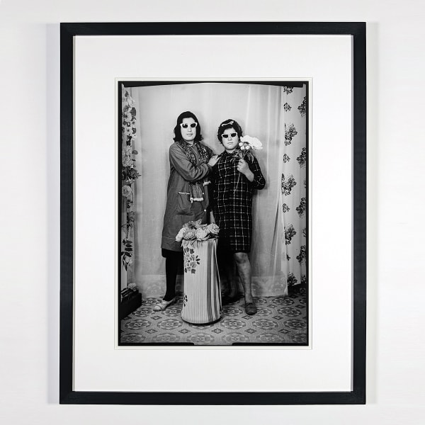Black and white photograph of two women wearing sunglasses and posing in a photo studio in Ain Beida, Algeria