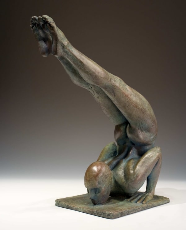 a bronze sculpture of a man doing a yoga pose
