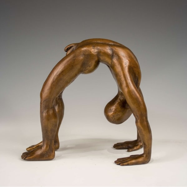 a bronze sculpture of a man doing a yoga pose