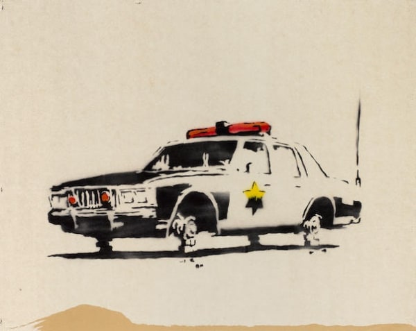 Banksy’s 2003 Police Car shown half-submerged, commentary on corruption and societal breakdown.