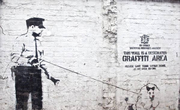 Banksy’s 2003 Graffiti Area stencil sign, witty street art commentary on urban creativity.