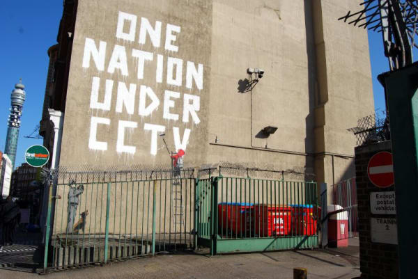 Banksy’s 2007 One Nation Under CCTV mural critiques surveillance with bold large-scale street art.