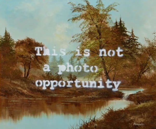 Banksy’s 2007 This is Not a Photo Opportunity stencil mocks staged protest imagery.