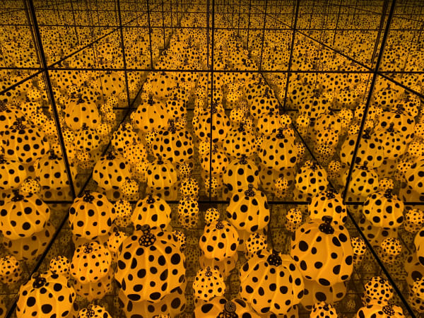 Yayoi Kusama, The Spirits of the Pumpkins Descended into the Heavens, immersive installation with glowing yellow pumpkin sculptures and mirrored reflections.