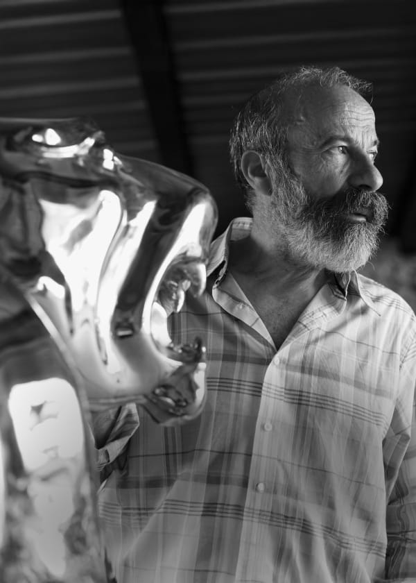 Arturo Di Modica standing next to the Stainless Steel Lion