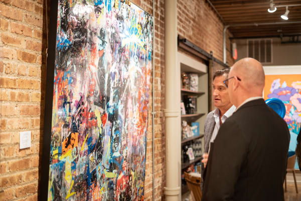 People in Carousel Fine Art's Chicago gallery space staring at paintings displayed.