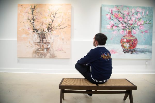 Artist Eric Alfaro in front of two of his artworks from the "Blossom" series in Carousel Fine Art gallery.
