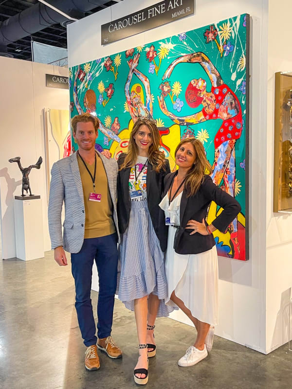 People posing in front of Carousel Fine Art's booth at the Palm Beach Show art fair, 2022.