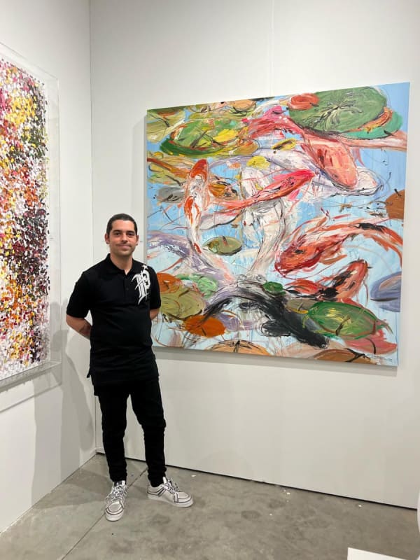 Man in front of Carousel Fine Art's booth at the art fair, Context Art Miami 2022.