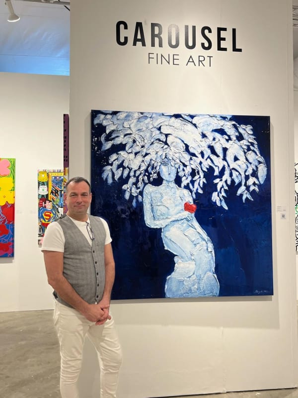 Man in front of painting at Carousel Fine Art's booth at the art fair, Context Art Miami 2022