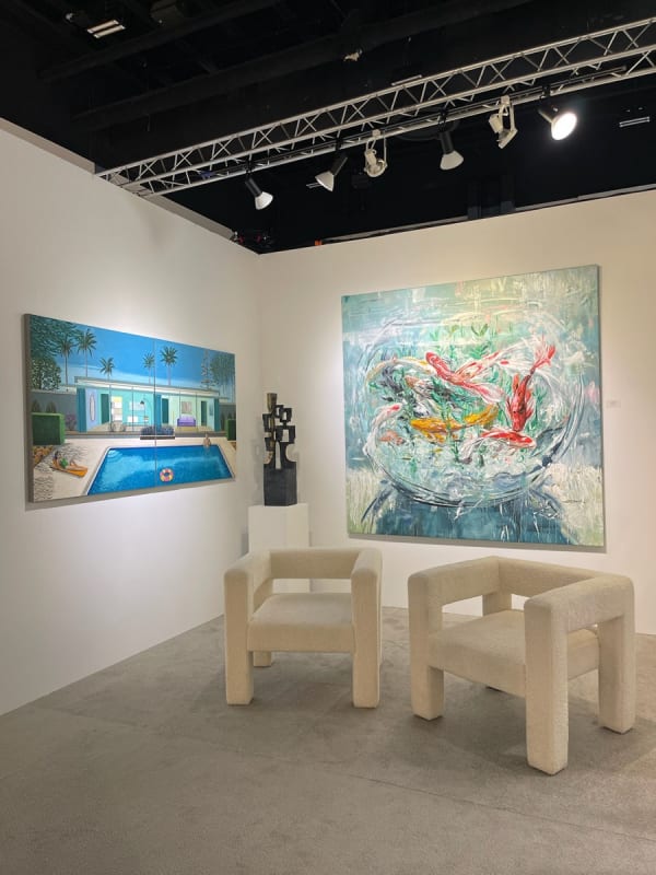 Two white chairs and paintings on the wall at Carousel Fine Art's gallery booth at art fair, Palm Beach Show 2024.