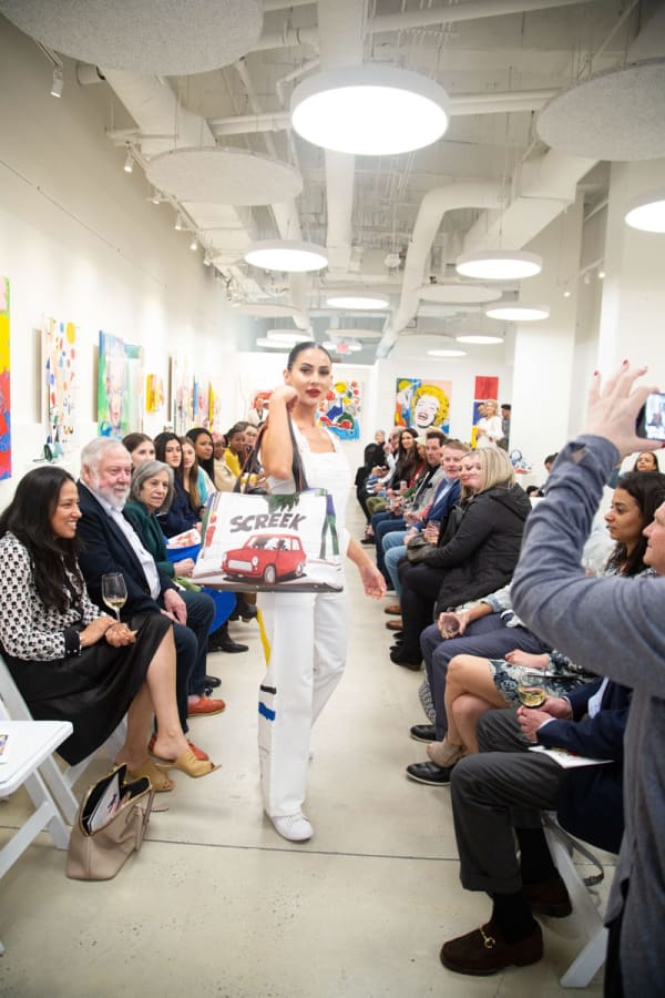 Model walking down runway in gallery space in Buckhead Village, Atlanta during the Caroline Dechamby Retrospective.
