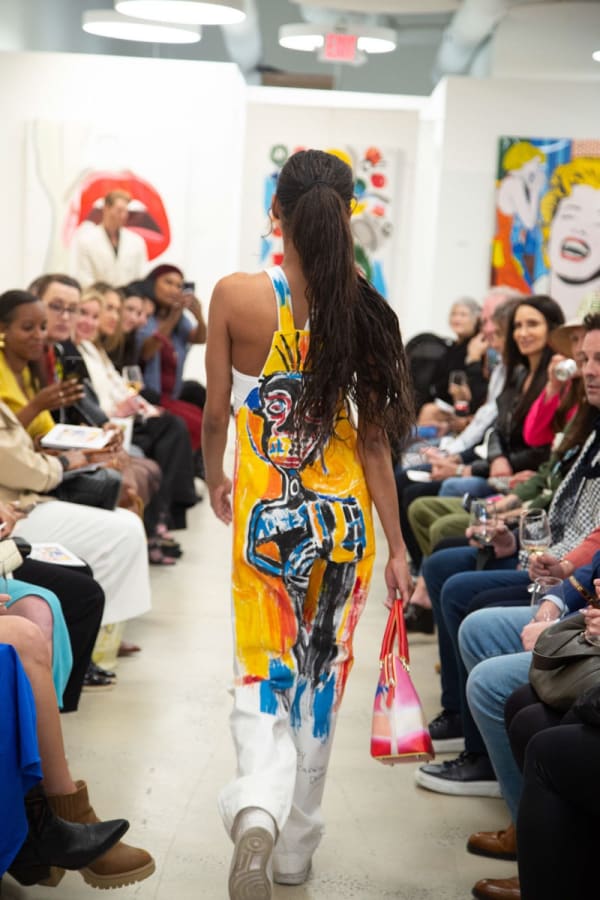 Model walking down runway in gallery space in Buckhead Village, Atlanta during the Caroline Dechamby Retrospective.
