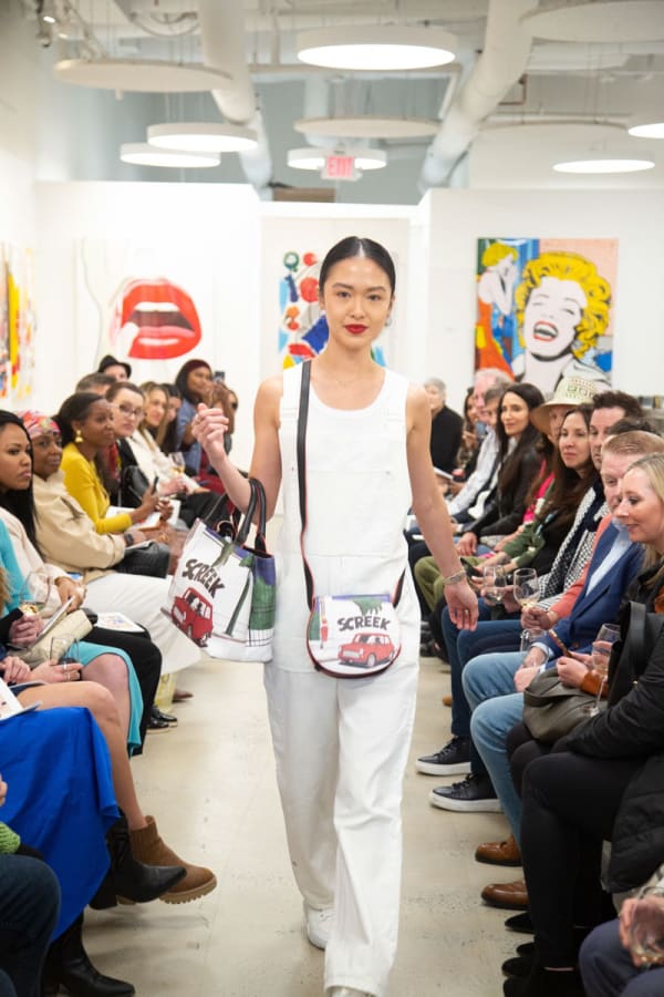 Model walking down runway in gallery space in Buckhead Village, Atlanta during the Caroline Dechamby Retrospective.