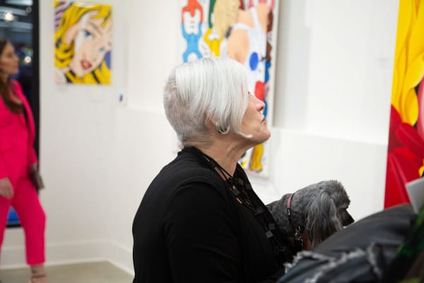 Woman with dog at Carousel Fine Art's gallery space in Buckhead Village, Atlanta during the Caroline Dechamby Retrospective.