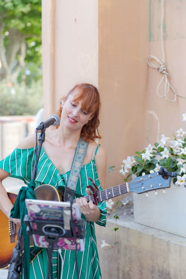 Woman playing music outside of Carousel Fine Art's gallery space in Saint Tropez.