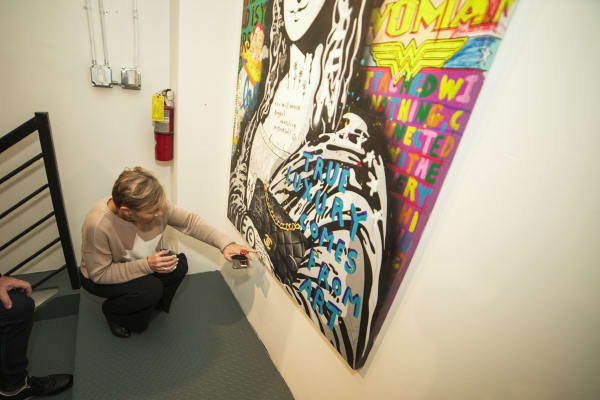 Woman pointing at painting in Carousel Fine Art's Miami gallery space during the Grand Opening.