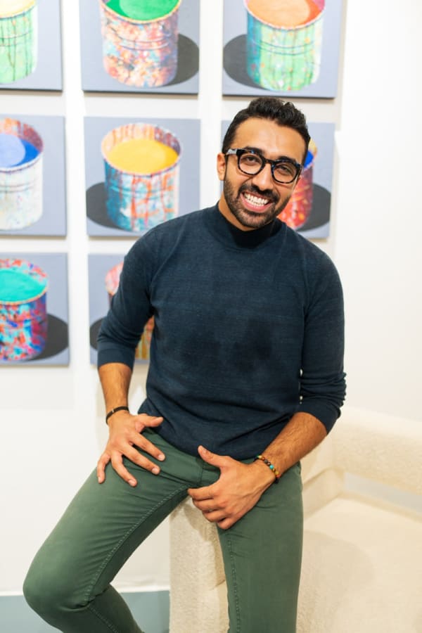 Man smiling on a couch in Carousel Fine Art's Miami gallery space during the Grand Opening.