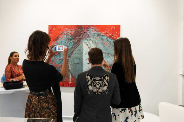 People staring at paintings displayed in Carousel Fine Art's Miami gallery space during the Grand Opening.