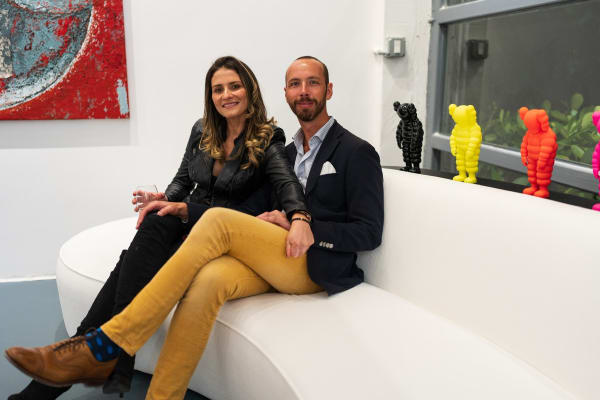 People on a couch in Carousel Fine Art's Miami gallery space during the Grand Opening.