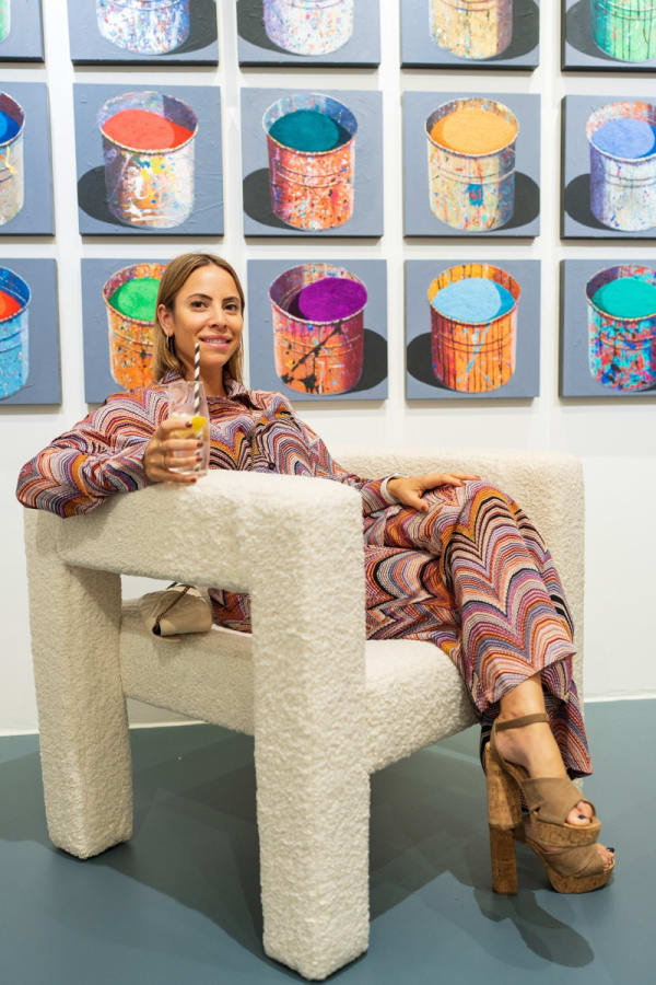 Woman sitting in chair in Carousel Fine Art's Miami gallery space during the Grand Opening.