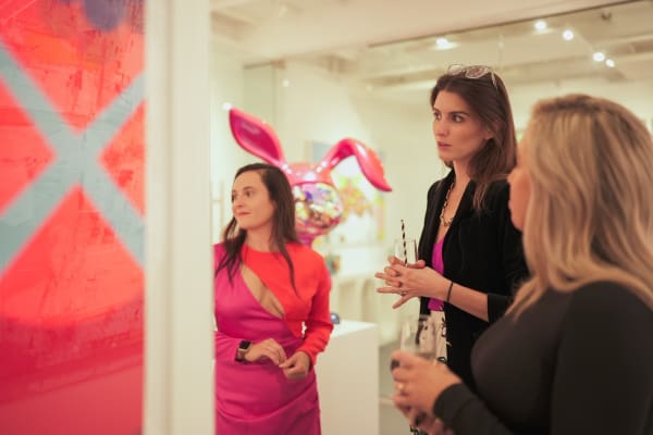 People staring at paintings displayed in Carousel Fine Art's Miami gallery space during the Grand Opening.