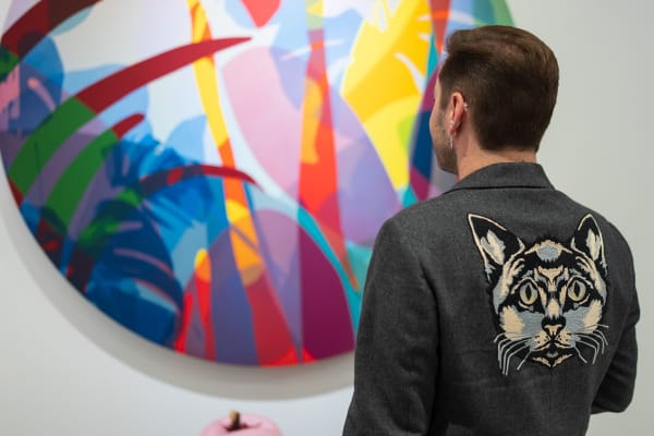 Man staring at paintings displayed in Carousel Fine Art's Miami gallery space during the Grand Opening.