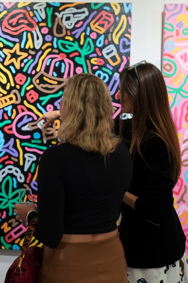 People staring at painting displayed in Carousel Fine Art's Miami gallery space during the Grand Opening.