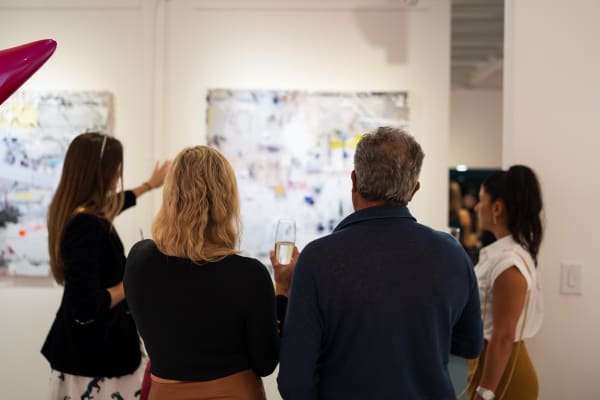 People pointing at painting in Carousel Fine Art's Miami gallery space during the Grand Opening.