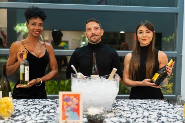 Bartenders holding wine bottles in Carousel Fine Art's Miami gallery space during the Grand Opening.