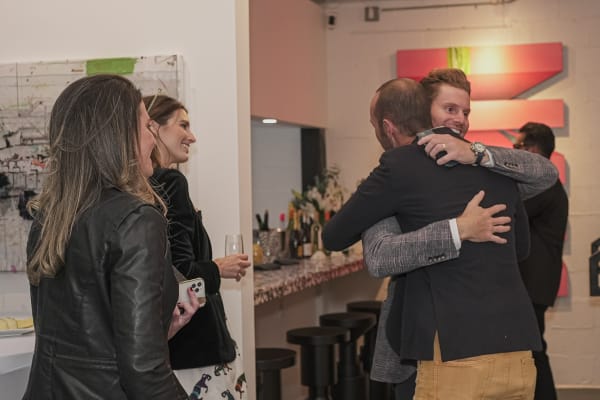 People hugging in Carousel Fine Art's Miami gallery space during the Grand Opening.